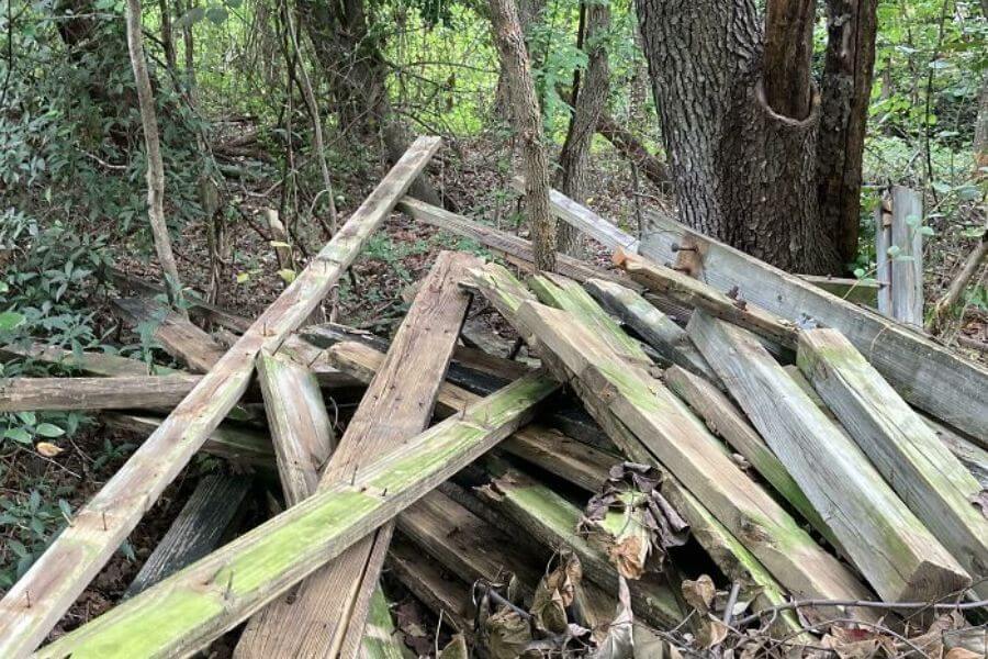 pile of Old Wood With Rusty Nails Sticking Out In The Woods