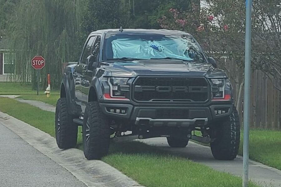 Big truck parked on top of the sidewalk