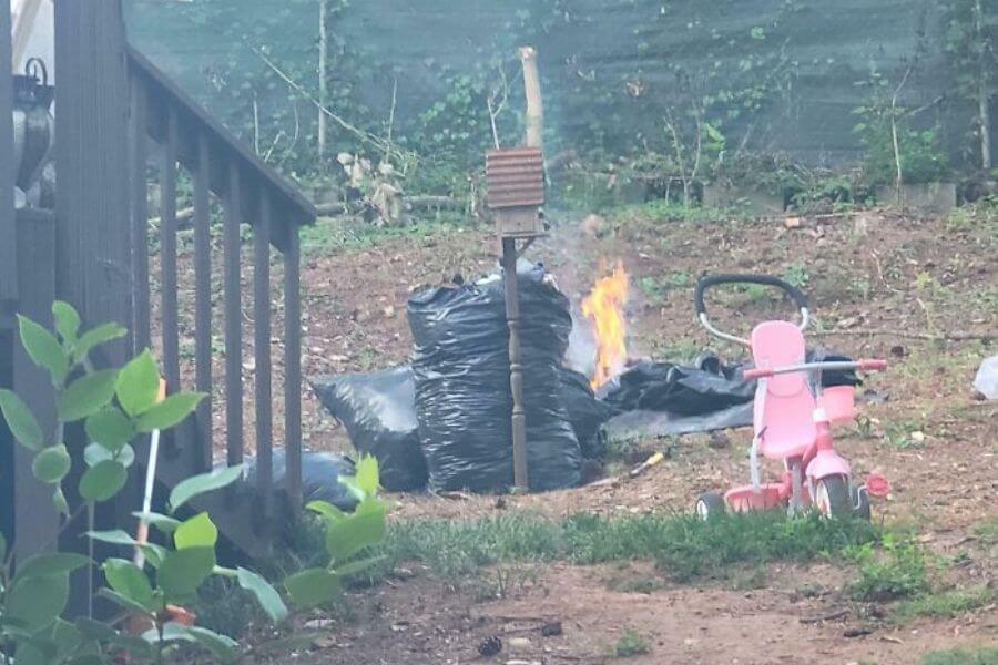 plastic bags being burned in a backyard